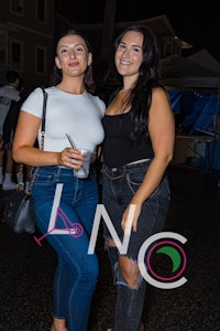 two women standing next to each other at night