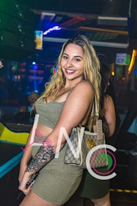 a woman in a green dress is posing for a photo at a nightclub