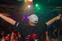 a man with his arms up in the air at a club