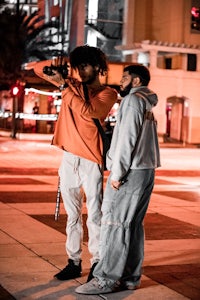 two men standing on a city street at night