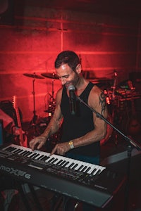 a man playing a keyboard in front of a microphone