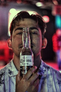 a man holding a bottle of corona