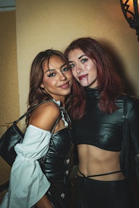 two women in black leather outfits posing for a photo