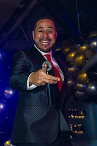 a man in a suit is holding a microphone