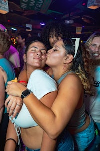 a group of girls hugging at a nightclub