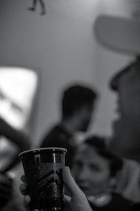 black and white photo of a man holding a cup