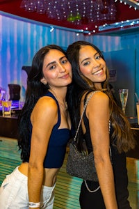 two women posing for a picture at a bar