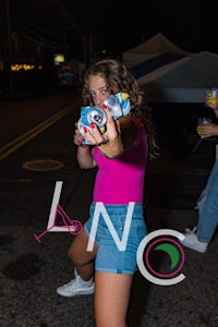 a girl is holding a beer bottle in her hand