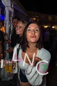 a woman is holding a drink at a party