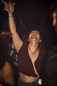 a woman is holding a drink at a party