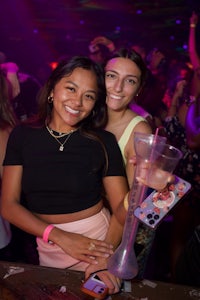 two women posing for a photo at a nightclub